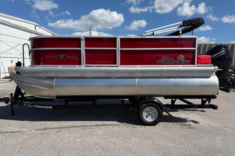 The Image of 2026 Sun Tracker Bass Buggy 16 XL Select pontoon boat on trailer, red and silver design. - 0