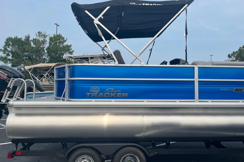 Slide: The Image of 2026 Sun Tracker Party Barge 20 DLX pontoon boat with blue exterior and canopy. - 2