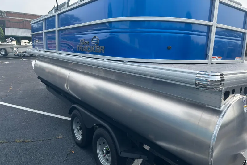 Slide: The Image of 2026 Sun Tracker Party Barge 20 DLX pontoon boat on trailer, blue and silver design. - 5