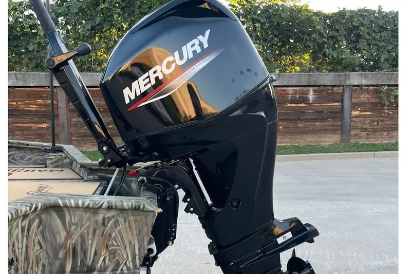 Slide: The Image of 2026 Tracker Grizzly 1756 T Marsh boat with Mercury outboard motor, parked outdoors. - 3