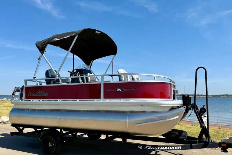 The Image of 2026 Sun Tracker Bass Buggy 16 XL Select pontoon boat by a lake. - 0