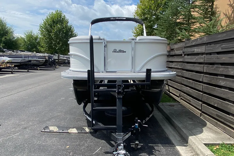 Slide: The Image of 2026 Sun Tracker Party Barge 22 XP3 pontoon boat on trailer in parking lot. - 3