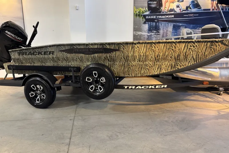 The Image of 2026 Tracker Grizzly 1650 T Prairie Wings Edition boat with camouflage design on trailer. - 0