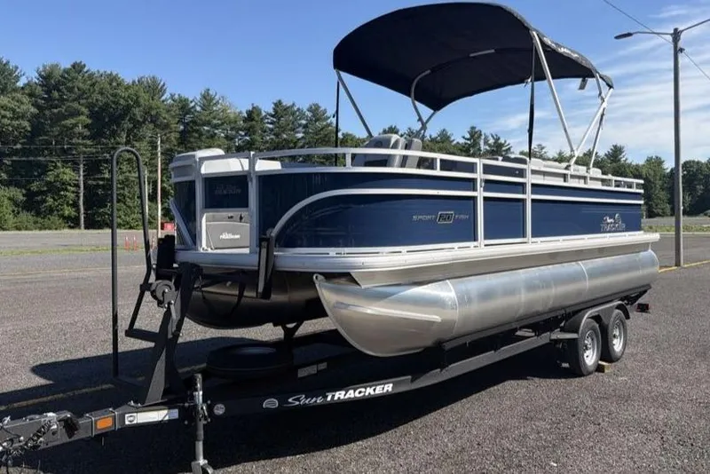 The Image of 2026 Sun Tracker SportFish 20 DLX pontoon boat on trailer, parked outdoors. - 0