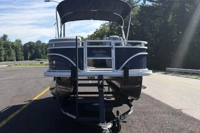 Slide: The Image of 2026 Sun Tracker SportFish 20 DLX pontoon boat on trailer, parked in sunny lot. - 6