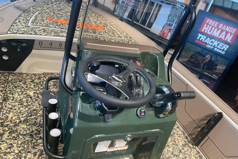 Slide: The Image of Interior view of 2026 Mako 18 Pro Skiff Backwater Edition with camo design and steering console. - 5
