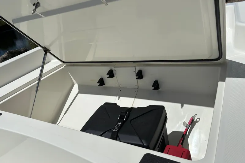 Slide: The Image of Open storage compartment of 2026 Mako Pro Skiff 15 CC boat. - 12
