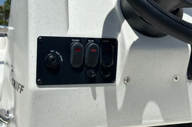 Slide: The Image of Control panel of 2026 Mako Pro Skiff 15 CC boat with switches and steering wheel. - 9