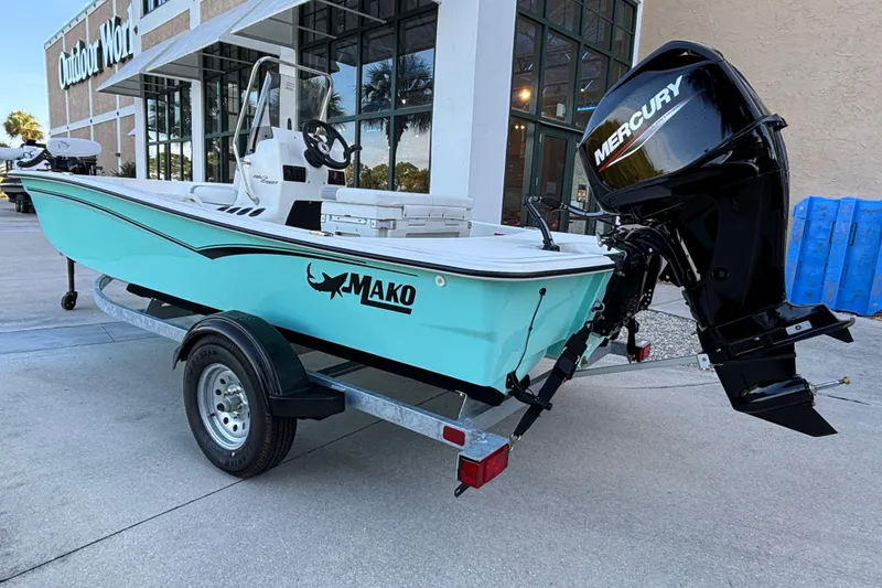 Slide: The Image of 2026 Mako Pro Skiff 15 CC boat with Mercury engine on trailer outside store. - 4