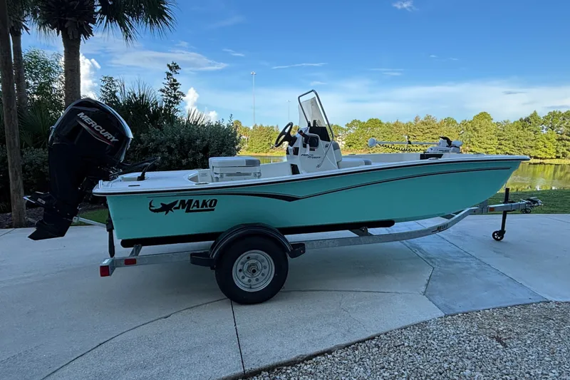 The Image of 2026 Mako Pro Skiff 15 CC boat on trailer, parked near a lake. - 0