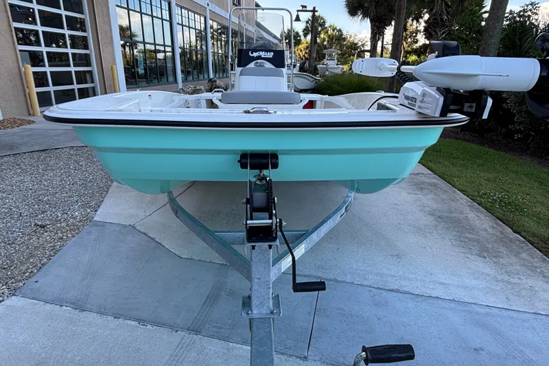 Slide: The Image of 2026 Mako Pro Skiff 15 CC boat on trailer, displayed outdoors. - 2