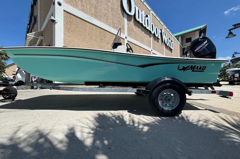 Slide: The Image of 2026 Mako Pro Skiff 15 CC boat displayed outside Outdoor World store. - 6