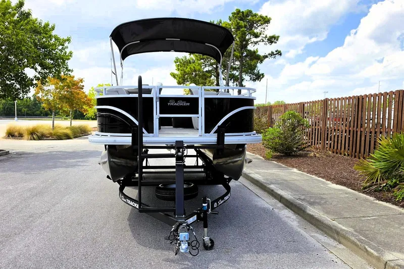 Slide: The Image of 2026 Sun Tracker Fishin' Barge 20 DLX pontoon boat on trailer, parked outdoors. - 10