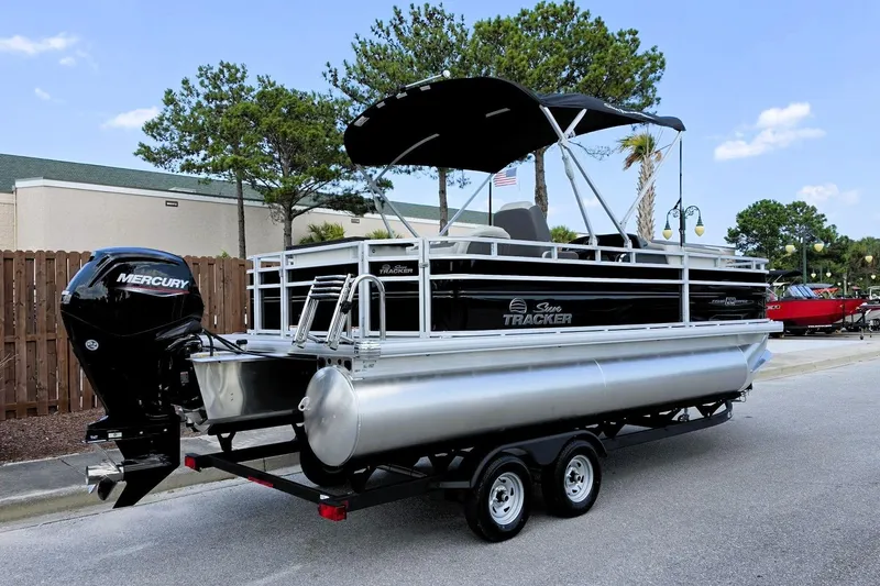 Slide: The Image of 2026 Sun Tracker Fishin' Barge 20 DLX pontoon boat with Mercury engine on trailer. - 2