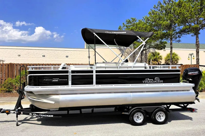 Slide: The Image of 2026 Sun Tracker Fishin' Barge 20 DLX pontoon boat on trailer, outdoors. - 6