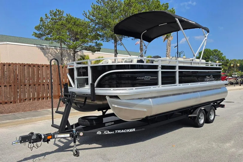 Slide: The Image of 2026 Sun Tracker Fishin' Barge 20 DLX pontoon boat on trailer, parked outdoors. - 7