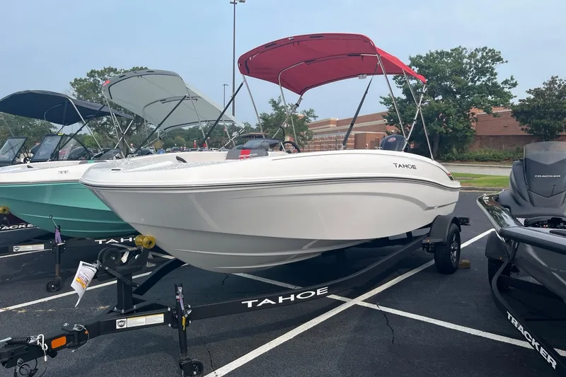 Slide: The Image of 2026 Tahoe T18 boat with red canopy on trailer in parking lot. - 1