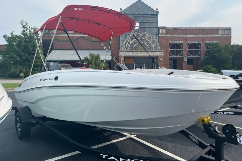 The Image of 2026 Tahoe T18 boat with red canopy on trailer, parked in front of a historic building. - 0
