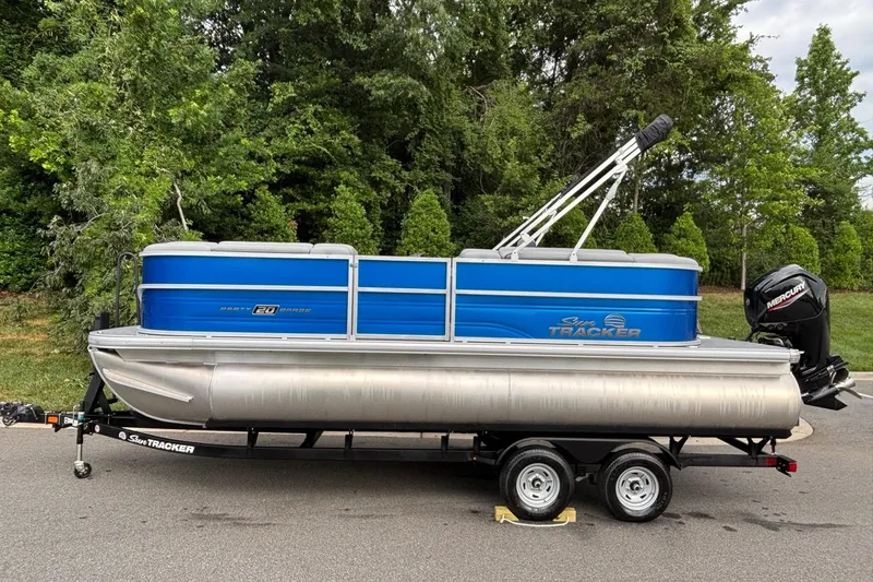 The Image of 2026 Sun Tracker Party Barge 20 DLX pontoon boat on trailer, parked outdoors. - 0