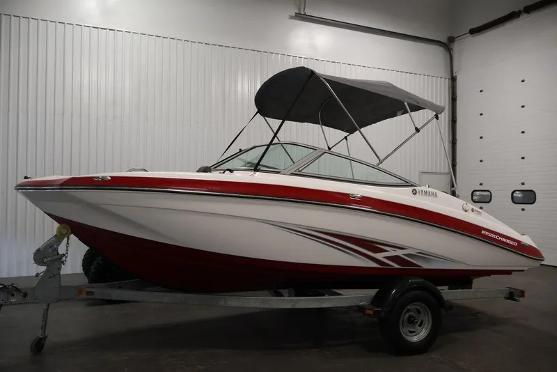 Slide: The Image of 2016 Yamaha Boats SX192 in a garage, featuring a red and white design with a canopy. - 40