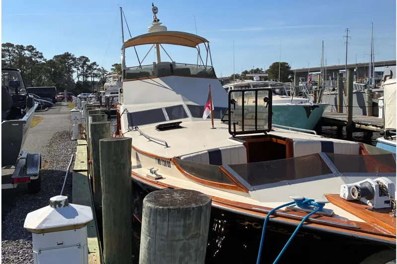 Slide: The Image of A 1987 Midnight Lace 44 Flybridge boat docked at a marina. - 3