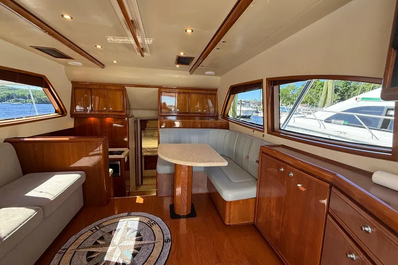 Slide: The Image of Luxurious interior of 2002 Bertram 390 Convertible yacht with wood finishes and seating area. - 12