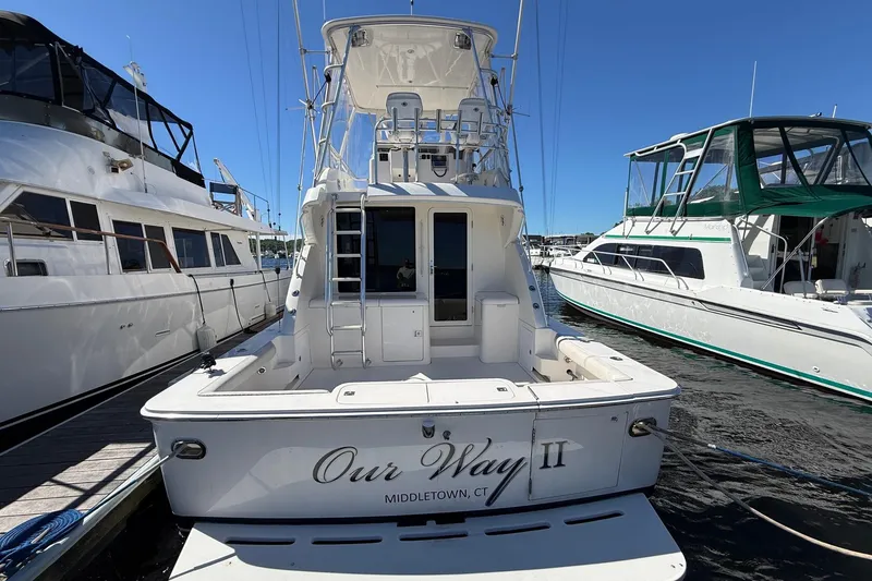 Slide: The Image of Bertram 390 Convertible 2002 docked, rear view, with neighboring boats in marina. - 5