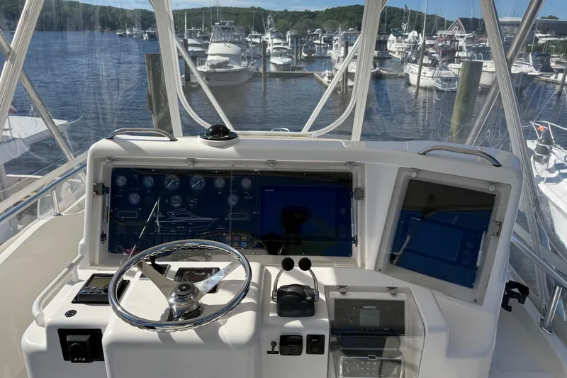 Slide: The Image of Helm of 2002 Bertram 390 Convertible yacht with marina view in the background. - 6