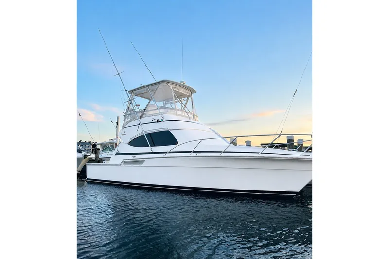 The Image of 2002 Bertram 390 Convertible yacht docked at sunset, showcasing sleek design and fishing capabilities. - 0