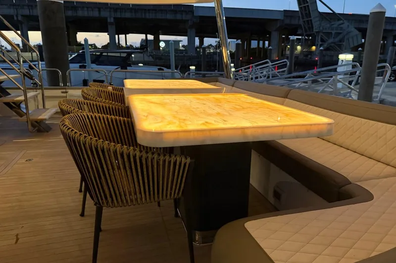 Slide: The Image of Luxurious dining area on 2024 Sirena 88 yacht with illuminated table and elegant seating. - 56