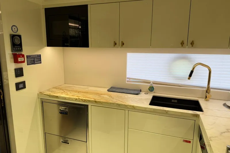 Slide: The Image of Modern kitchen interior on 2024 Sirena 88 yacht, featuring sleek cabinetry and marble countertops. - 153