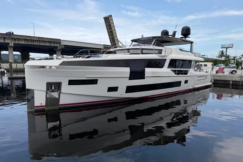 The Image of 2024 Sirena 88 yacht docked, reflecting on calm water under a blue sky. - 0