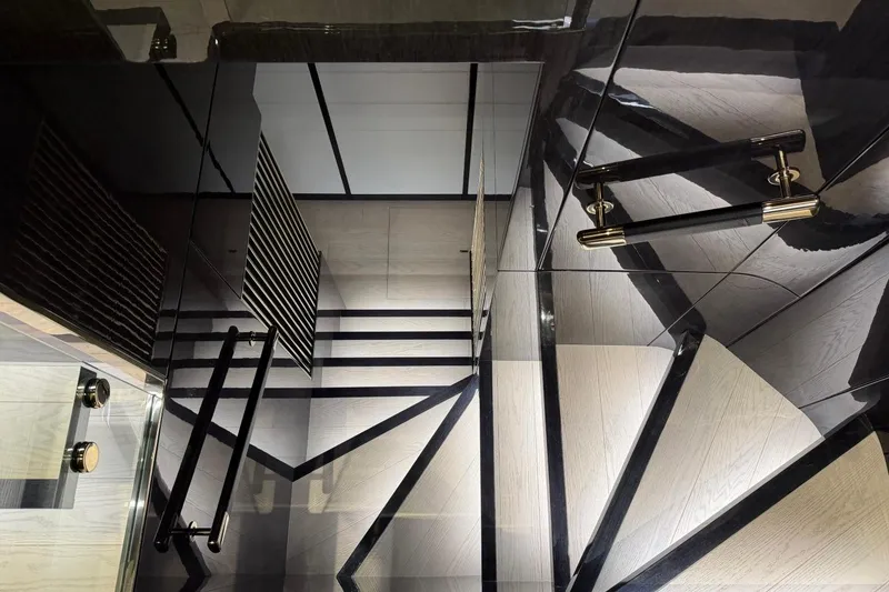 Slide: The Image of Luxurious interior staircase of 2024 Sirena 88 yacht, featuring sleek black and wood design. - 135