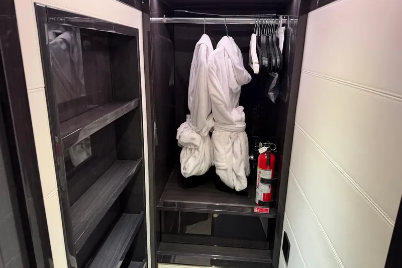 Slide: The Image of Luxurious closet in 2024 Sirena 88 yacht with robes and fire extinguisher. - 84