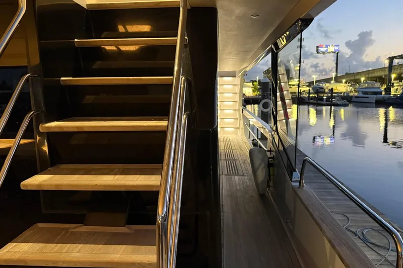 Slide: The Image of Luxurious 2024 Sirena 88 yacht interior with wooden stairs and marina view at dusk. - 58