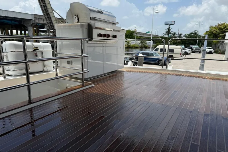 Slide: The Image of Wet wooden deck of 2024 Sirena 88 yacht with stainless steel railings and outdoor grill. - 44