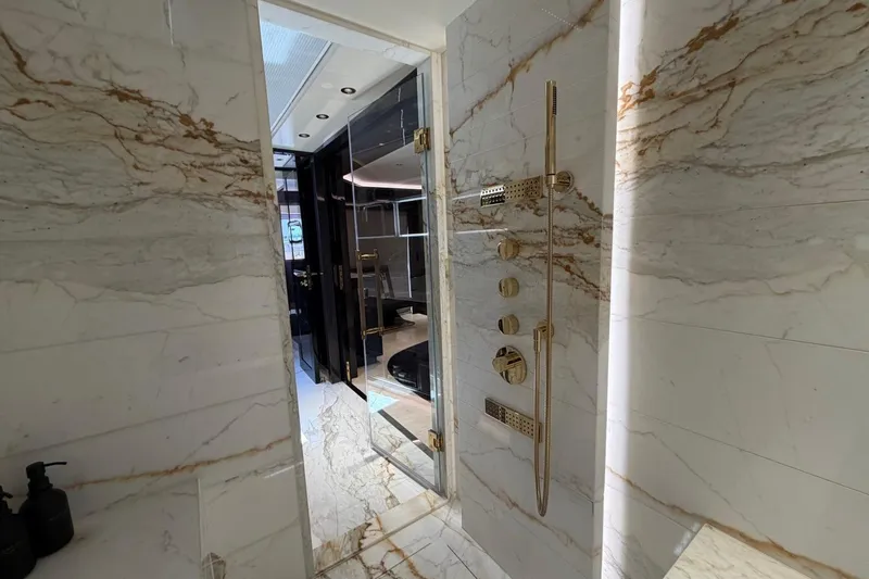 Slide: The Image of Luxurious marble bathroom interior on the 2024 Sirena 88 yacht, featuring elegant gold fixtures. - 127