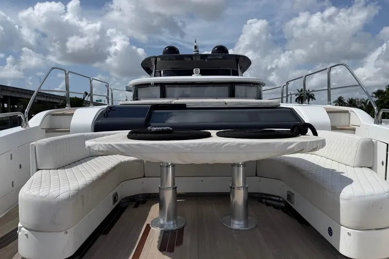 Slide: The Image of Luxurious 2024 Sirena 88 yacht with elegant seating and table on deck under a cloudy sky. - 96