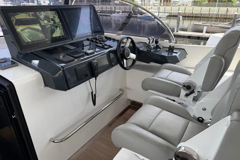 Slide: The Image of 2024 Sirena 88 yacht helm with dual seats, advanced navigation screens, and sleek controls. - 8