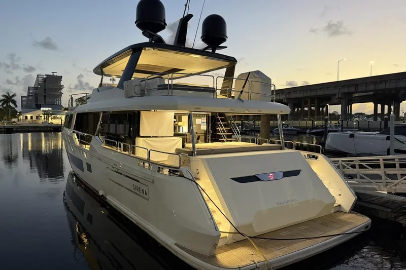 Slide: The Image of Luxury 2024 Sirena 88 yacht docked at sunset, illuminated and elegant. - 61