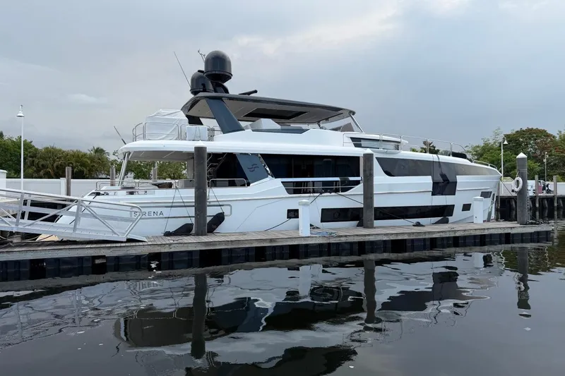 Slide: The Image of Luxury 2024 Sirena 88 yacht docked at marina, reflecting on calm water. - 4