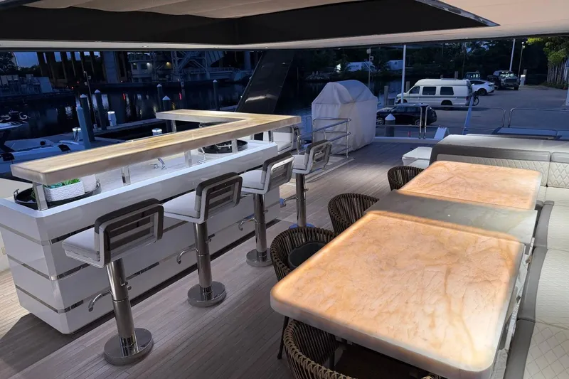 Slide: The Image of Luxurious 2024 Sirena 88 yacht deck with elegant bar and seating area at dusk. - 15