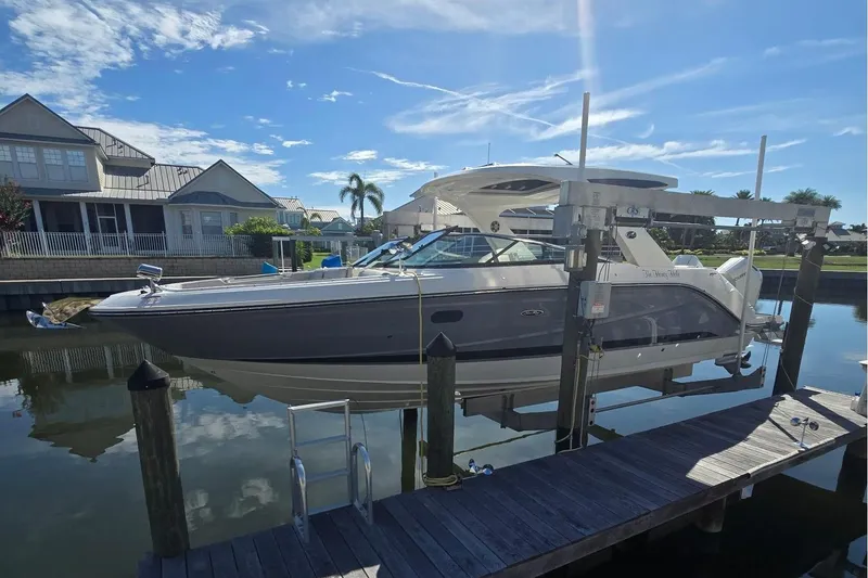 The Image of A 2024 Sea Ray SLX 310 Outboard boat is docked in a calm harbor setting. - 0