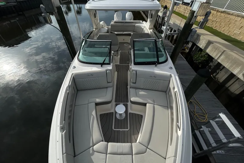 Slide: The Image of 2024 Sea Ray SLX 310 Outboard boat with spacious seating and sleek design at dock. - 101