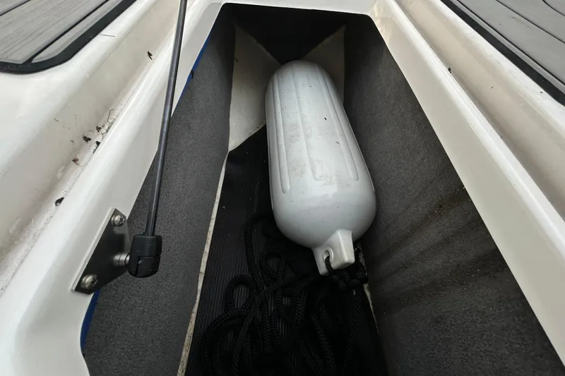 Slide: The Image of Storage compartment of 2024 Sea Ray SLX 310 Outboard with a boat fender. - 107