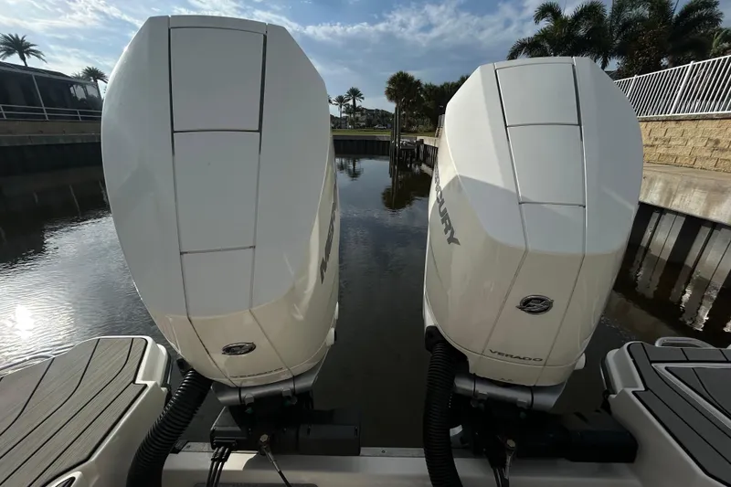 Slide: The Image of 2024 Sea Ray SLX 310 Outboard engines on calm water, surrounded by palm trees. - 135