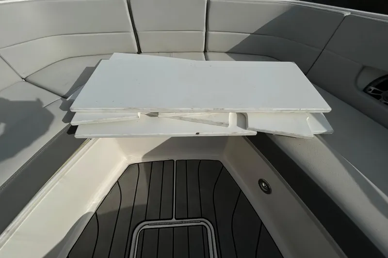 Slide: The Image of 2024 Sea Ray SLX 310 Outboard interior with foldable table and cushioned seating. - 138