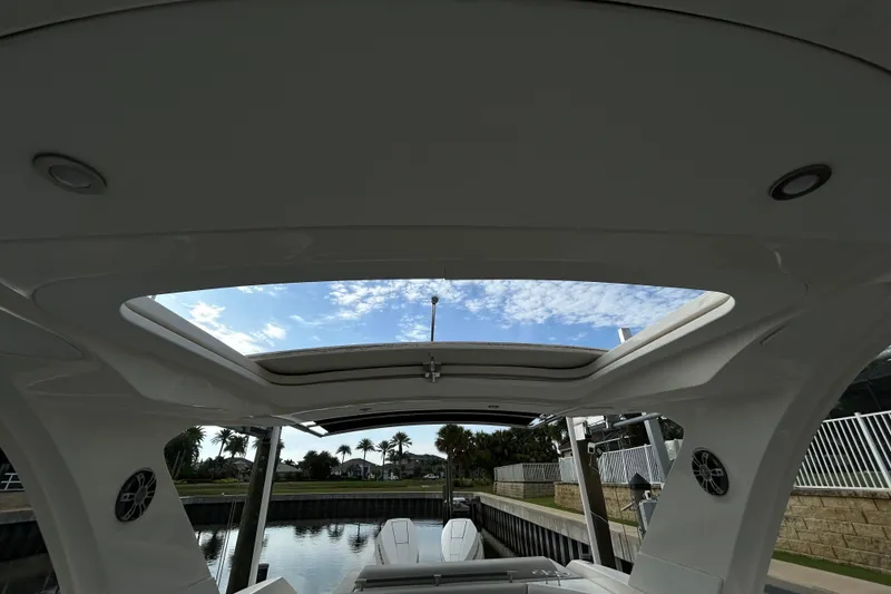 Slide: The Image of 2024 Sea Ray SLX 310 Outboard boat interior with open sunroof and scenic view. - 145
