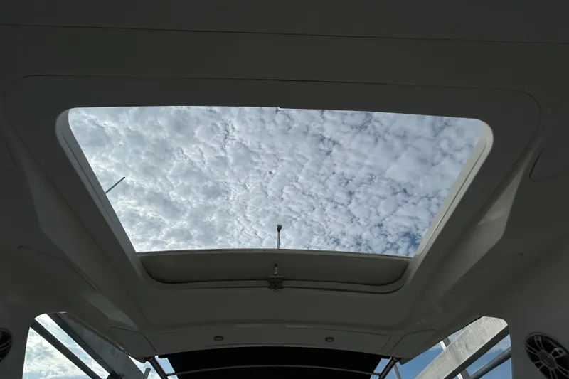 Slide: The Image of 2024 Sea Ray SLX 310 Outboard sunroof view with cloudy sky. - 146