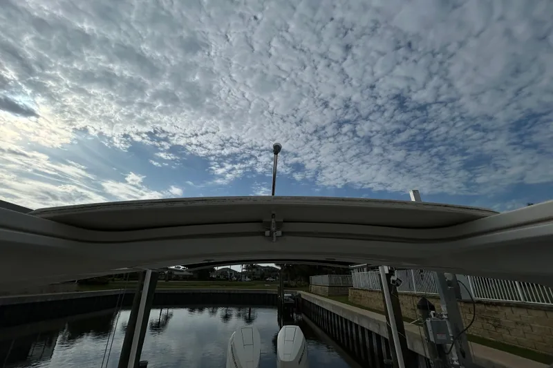 Slide: The Image of 2024 Sea Ray SLX 310 Outboard under cloudy sky at a dock. - 147